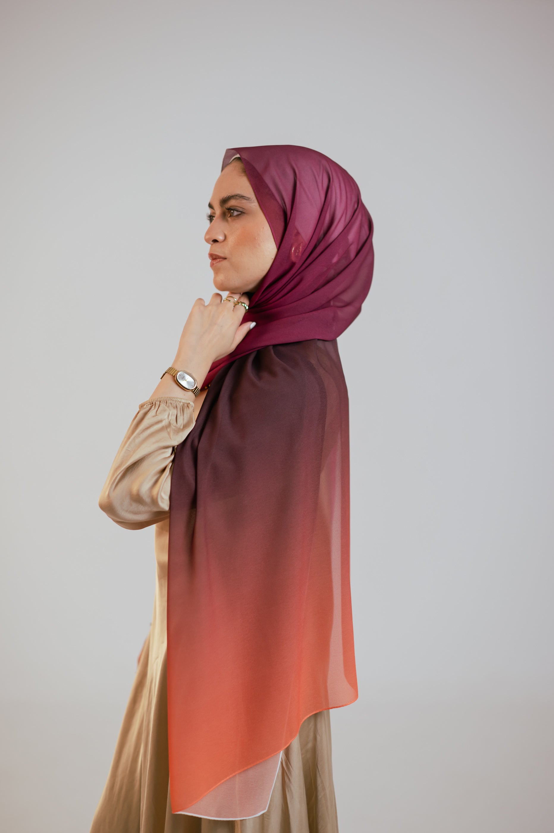 Side profile of the Wisteria Sunset chiffon hijab in warm studio lighting showcasing the rich gradient.