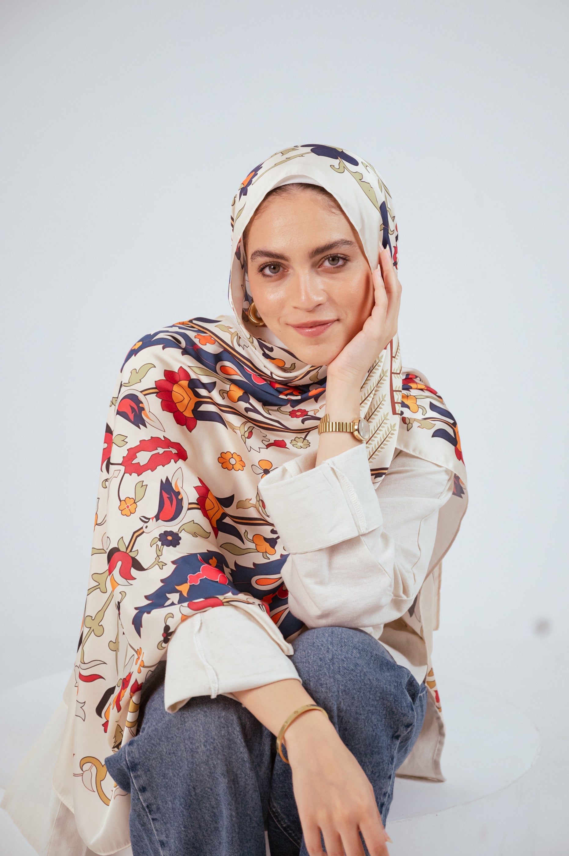 Model wearing the Andalus Satin Hijab in an ivory and gold Andalusian pattern, front view
