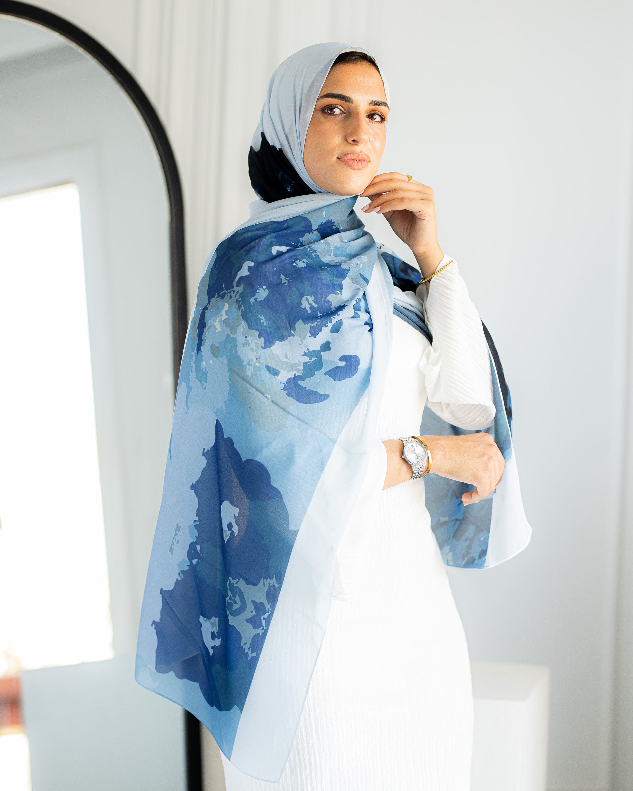 Model styling Jaida Azure Bloom chiffon hijab in a casual modest outfit, draped over white dress
