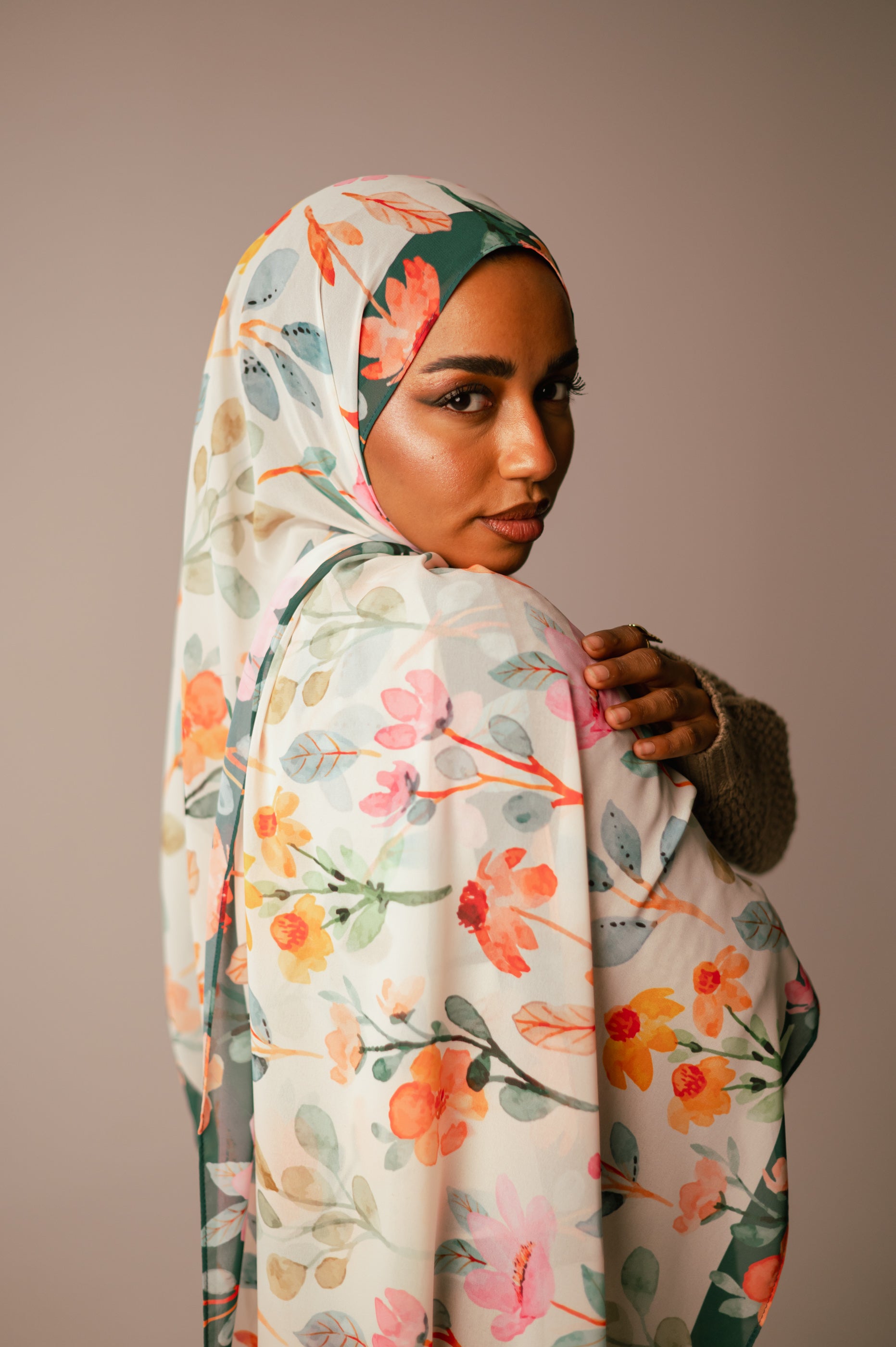 Close-up of Blooms of Hope chiffon hijab on the shoulder showcasing intricate watercolor floral details.