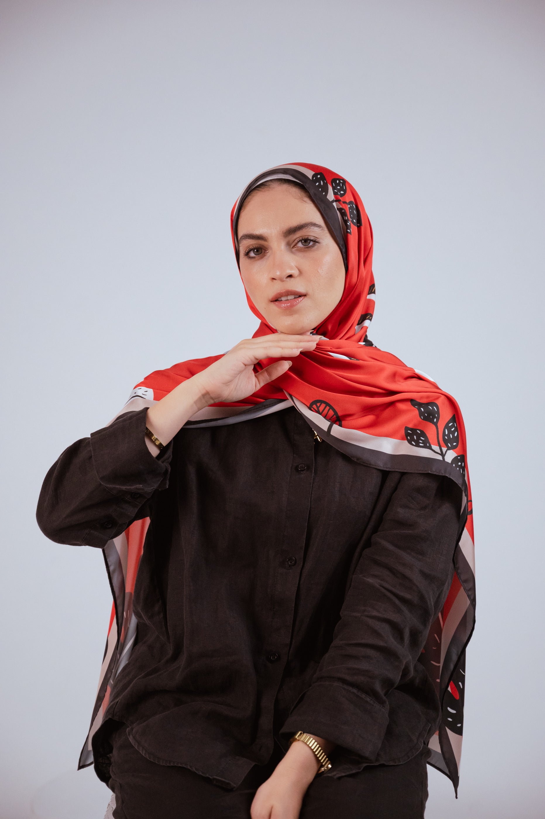 Close-up front portrait of the model wearing the Bold Botanica satin hijab, focusing on the wrap style and vibrant print.