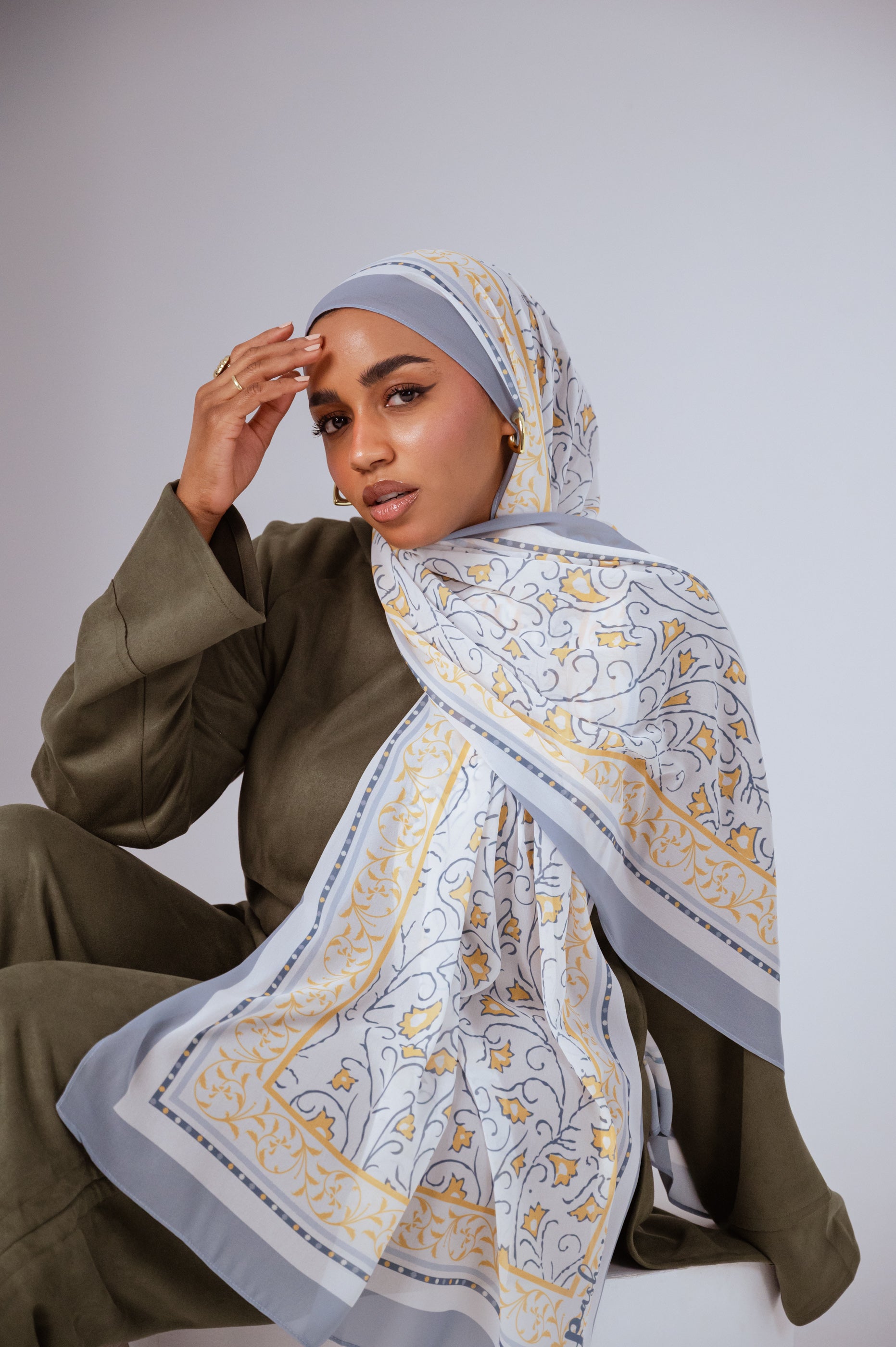 Full view of the Ciel Doré luxury chiffon hijab, showcasing its warm golden gradient and airy drape.