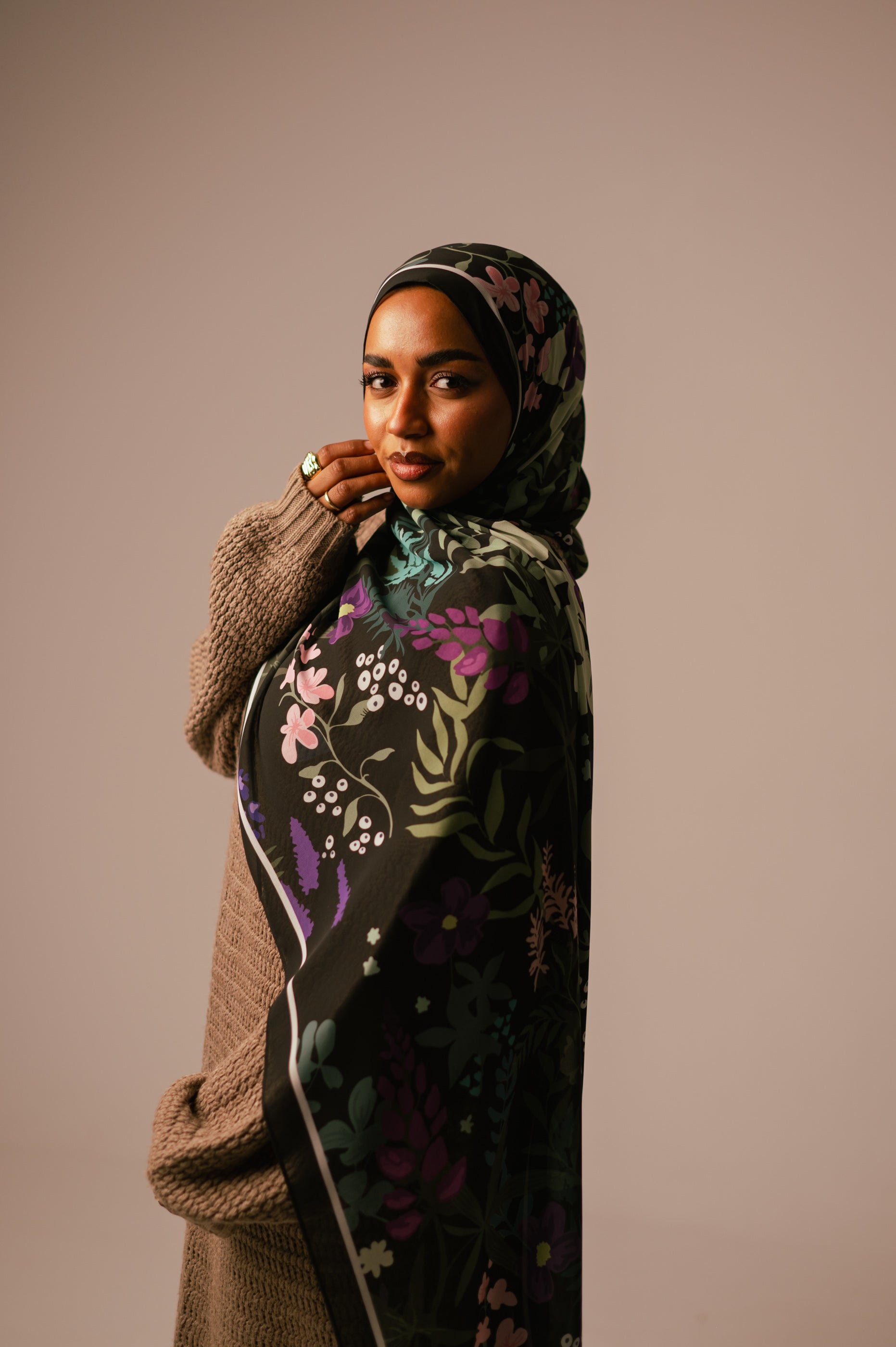 Model wearing the Garden of Whispers chiffon hijab, showing a soft side pose with warm studio lighting.