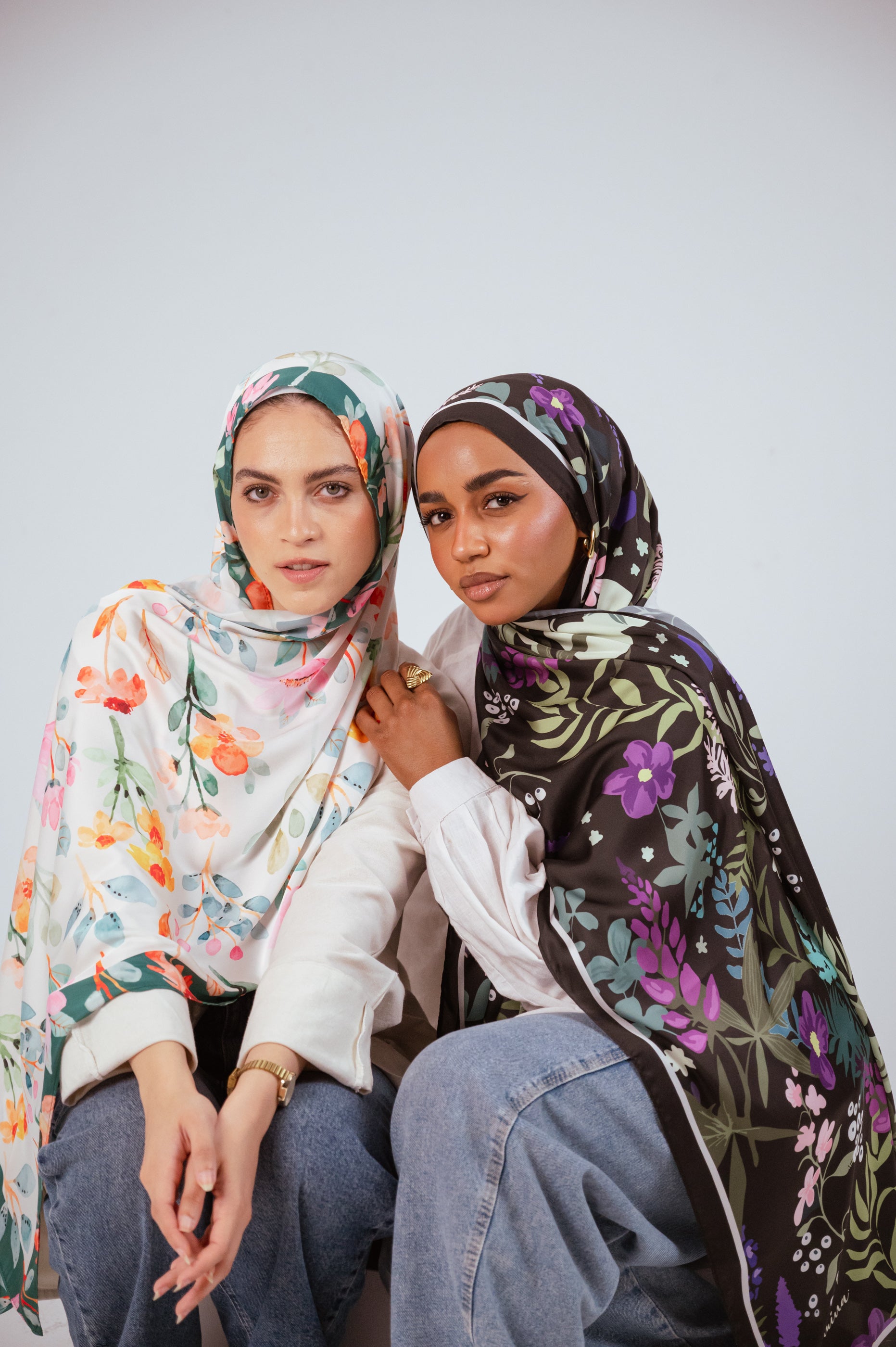 Close portrait of two women modeling Garden of Whispers and Blooms of Hope satin hijabs.