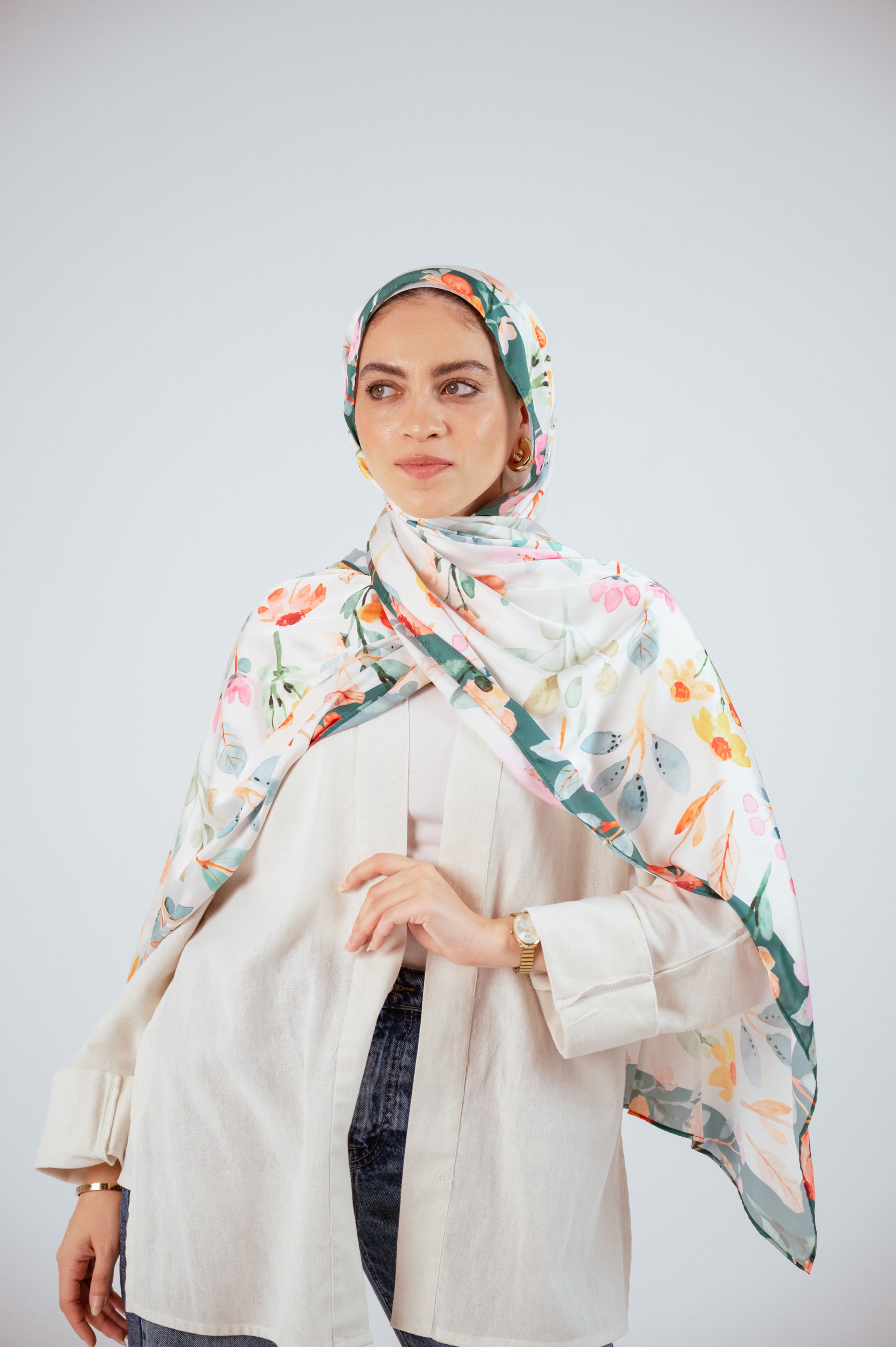 Model wearing Blooms of Hope – Luxury Satin Hijab draped over shoulders, showing full floral print.