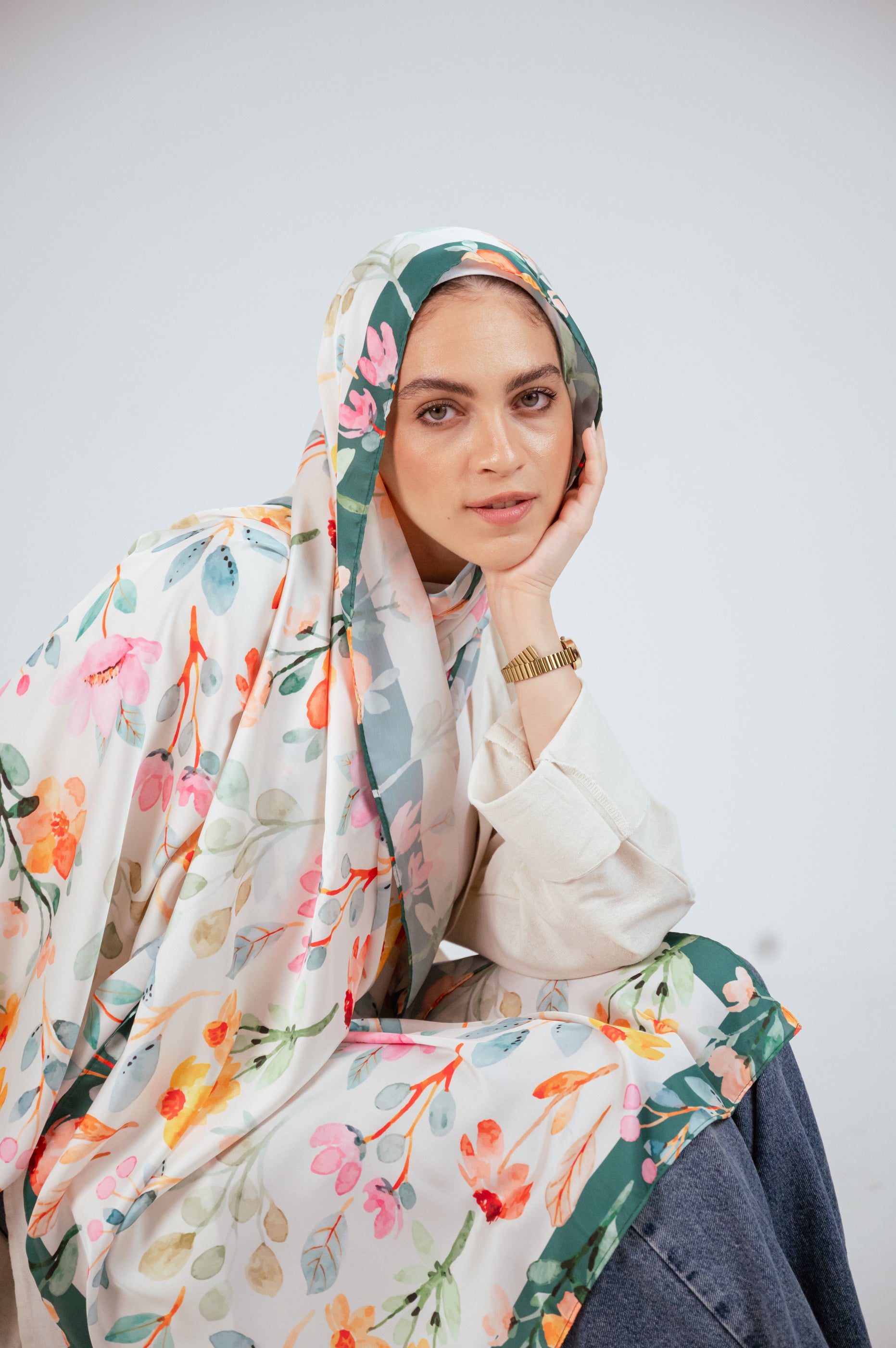 Close-up of Blooms of Hope – Luxury Satin Hijab framing the face, showing print detail and green edge.
