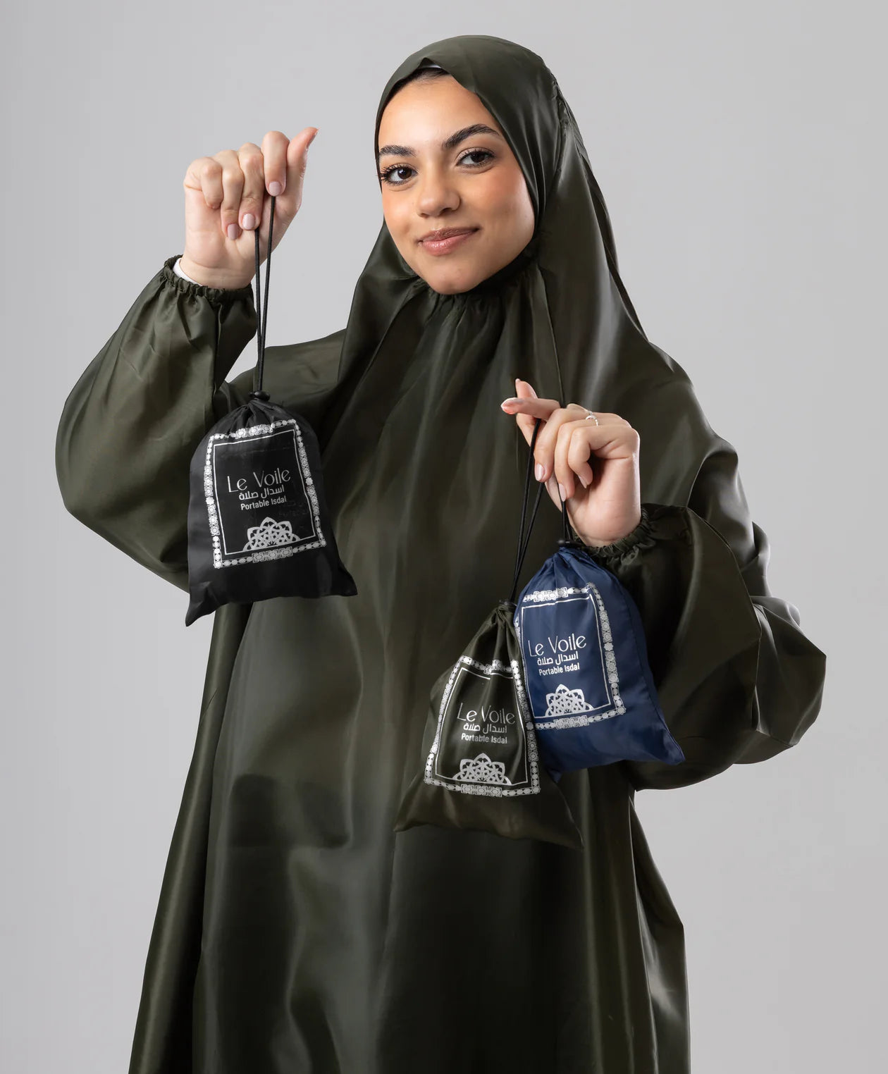 Portable prayer isdal folded into its compact carry pouch, held in one hand — JAIDA