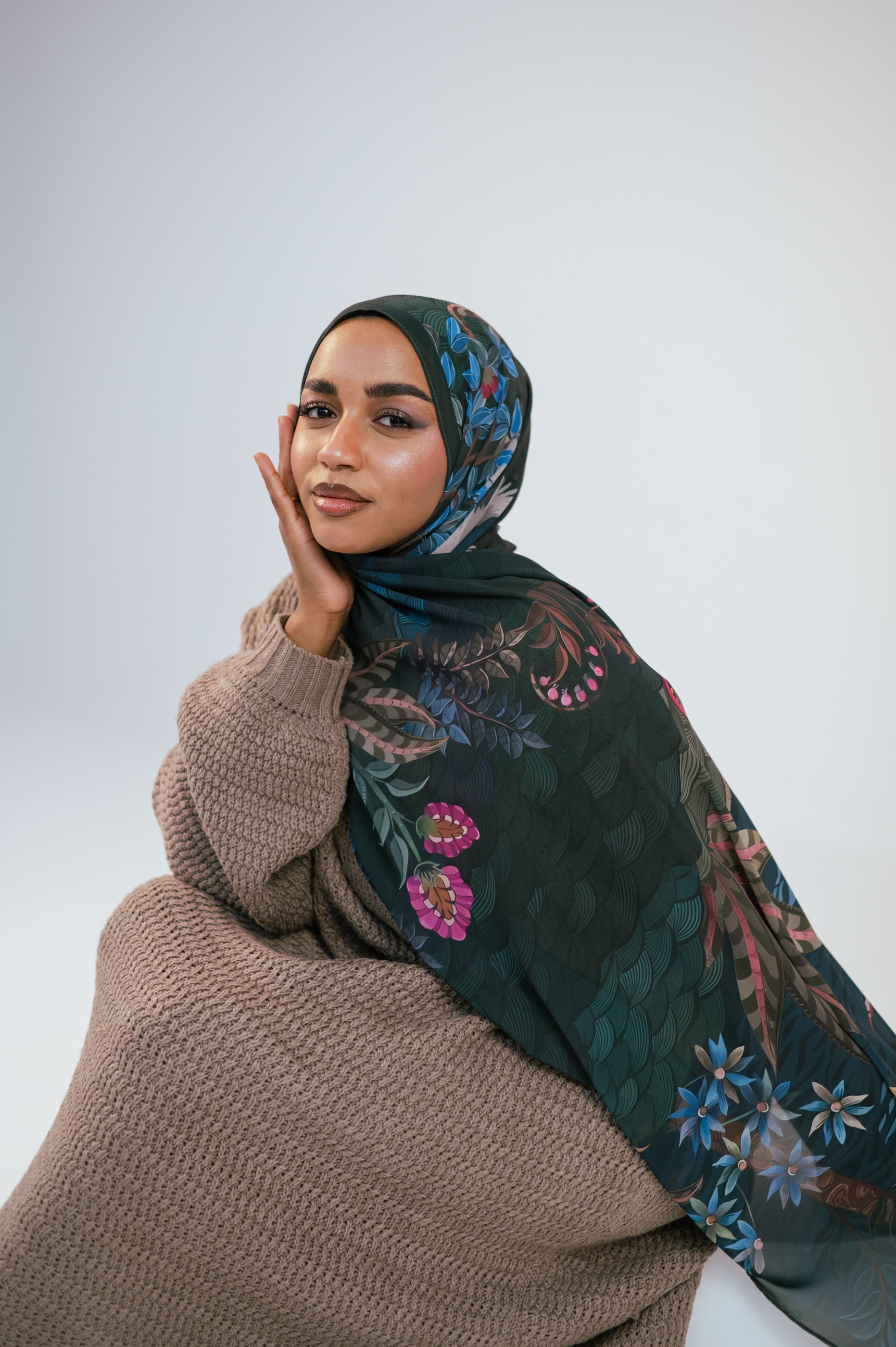Soft seated portrait of Secret Garden Luxury Chiffon Hijab showing floral pattern and elegant drape.