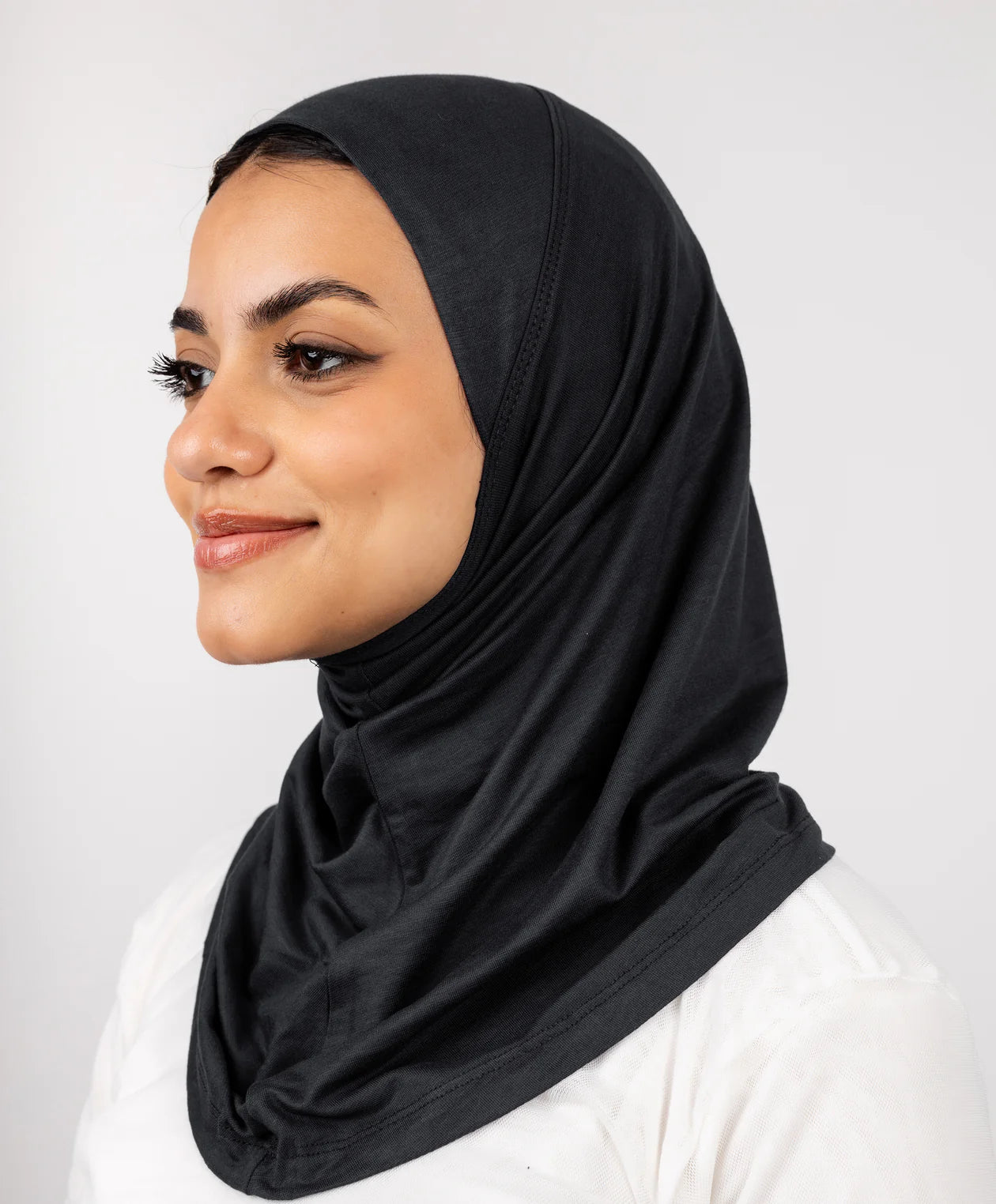 Black Syrian full-neck underscarf worn by a model, covering head, ears, and neck — JAIDA
