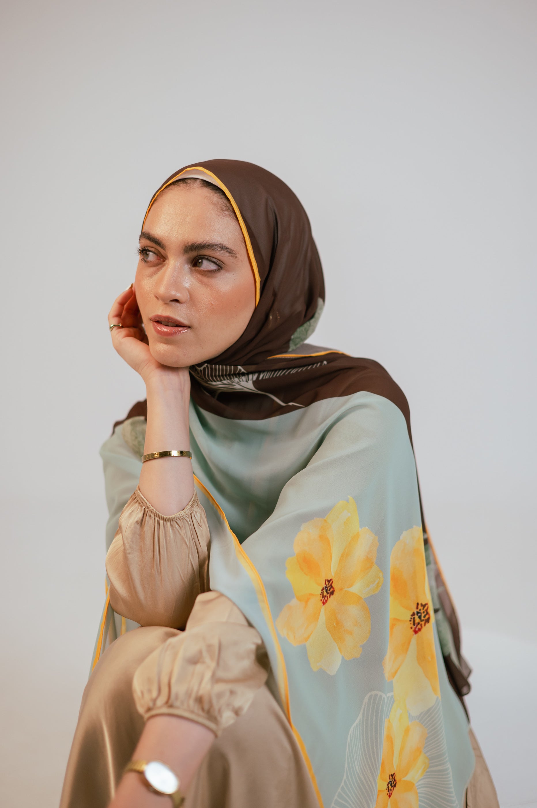 Side angle showing the Terra Soleil chiffon hijab with large yellow flower motifs and soft aqua borders.