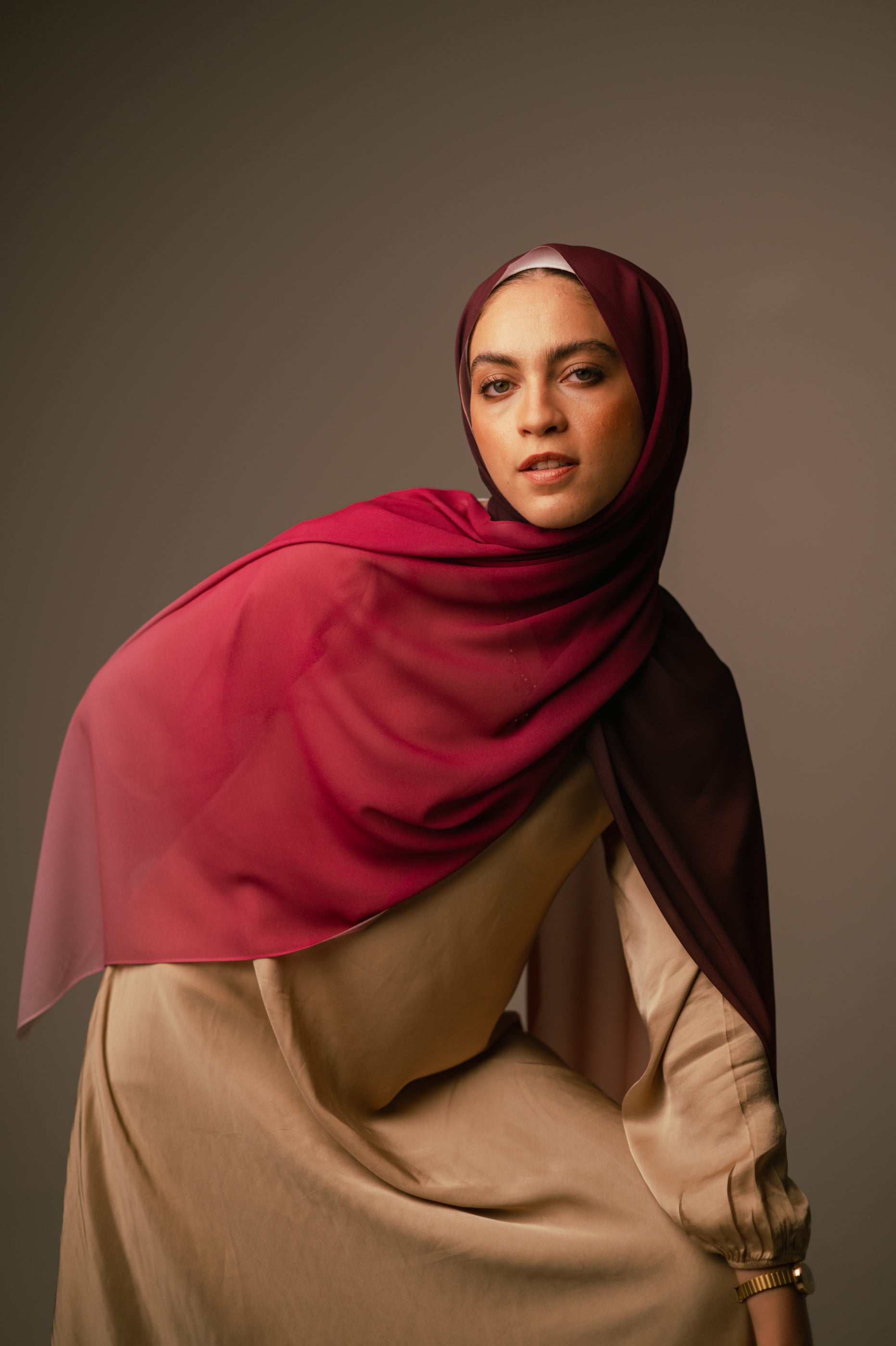 Editorial pose of the model wearing the Wisteria Sunset hijab with dramatic draping and deep pink tones.