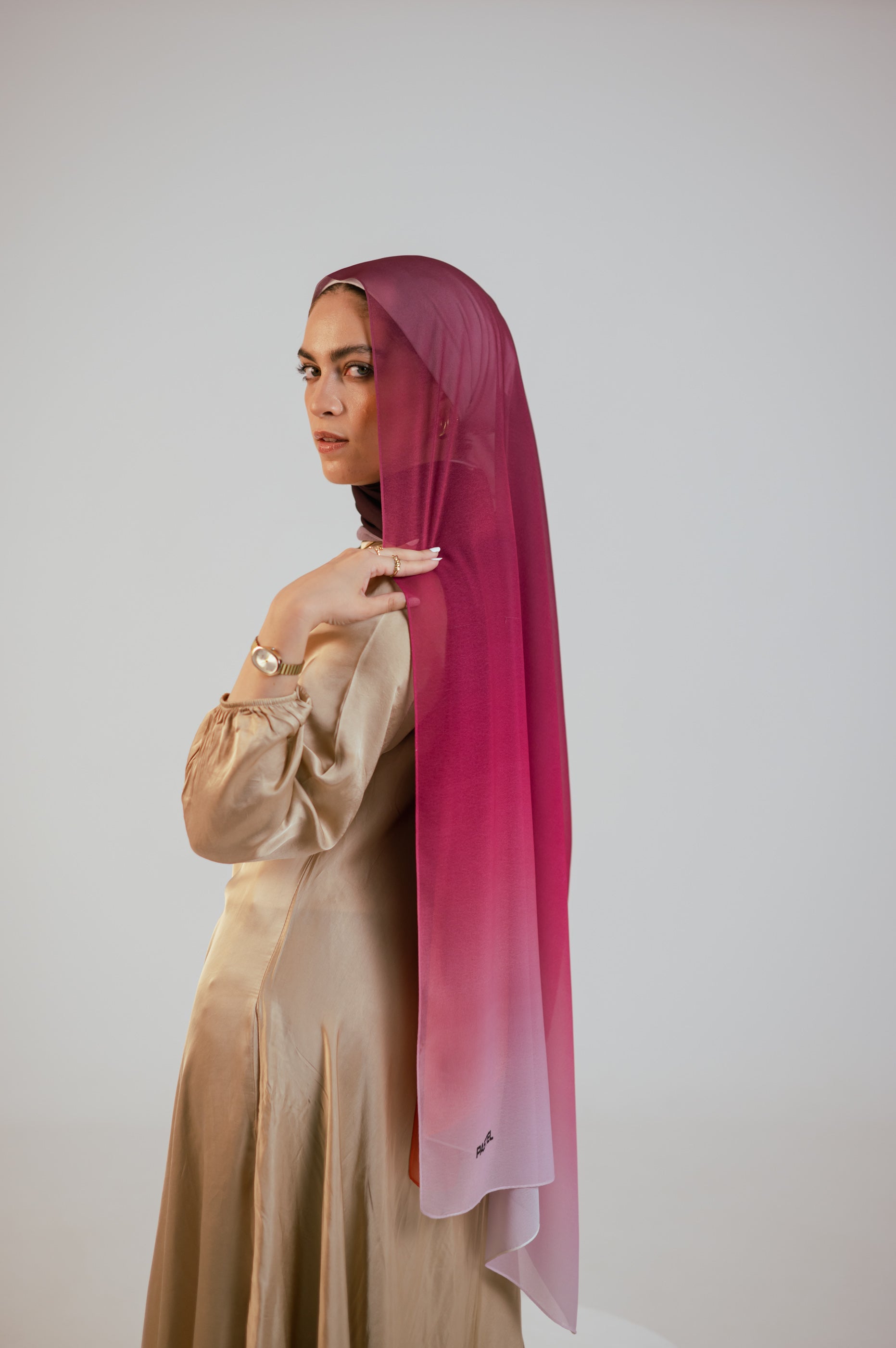 Model wearing the Wisteria Sunset luxury chiffon hijab in a rich pink-to-plum ombré, side profile with soft drape.