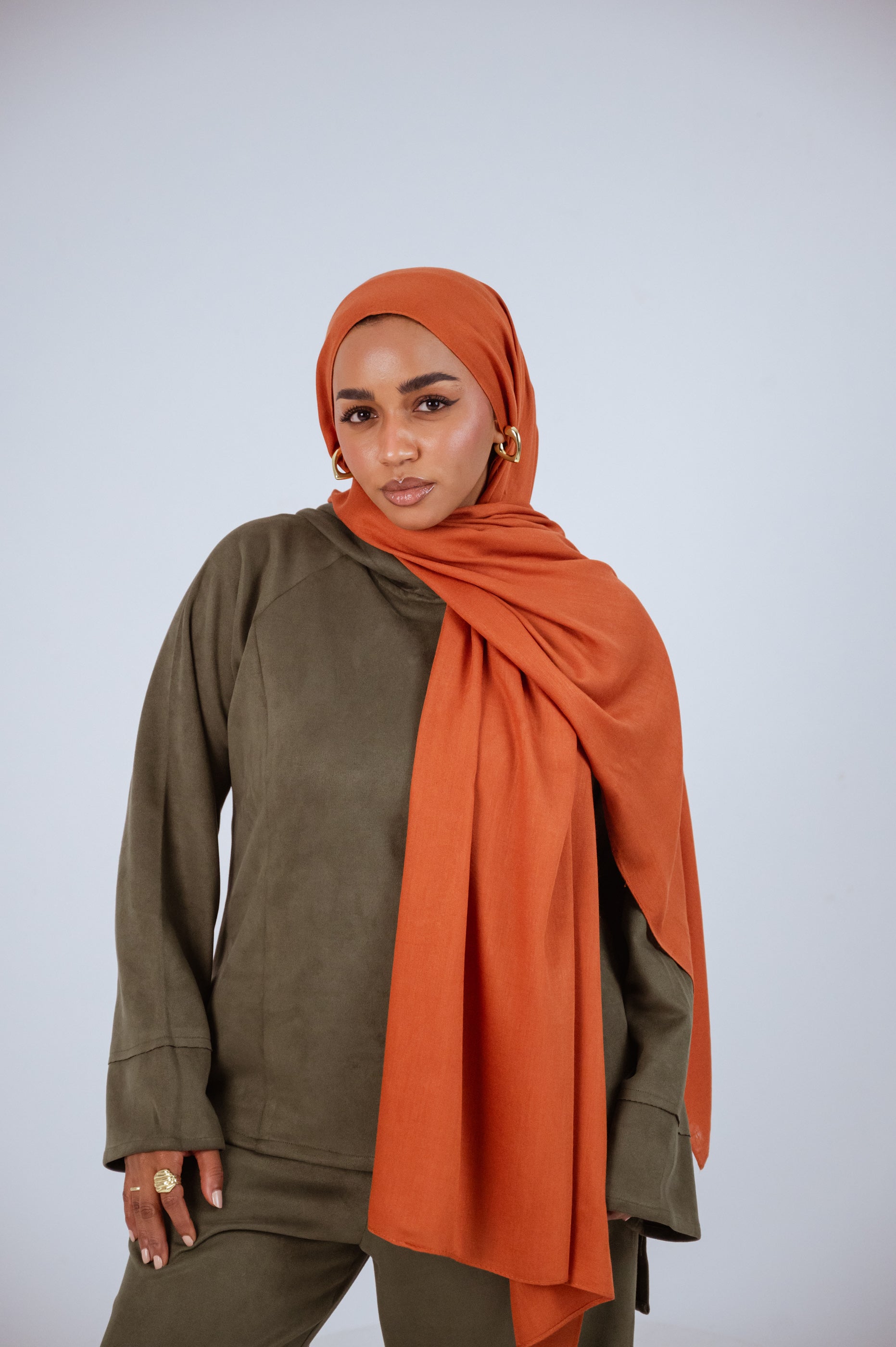 Model wearing Afire Modal Cotton Hijab styled in front drape – elegant rust hue for everyday wear.