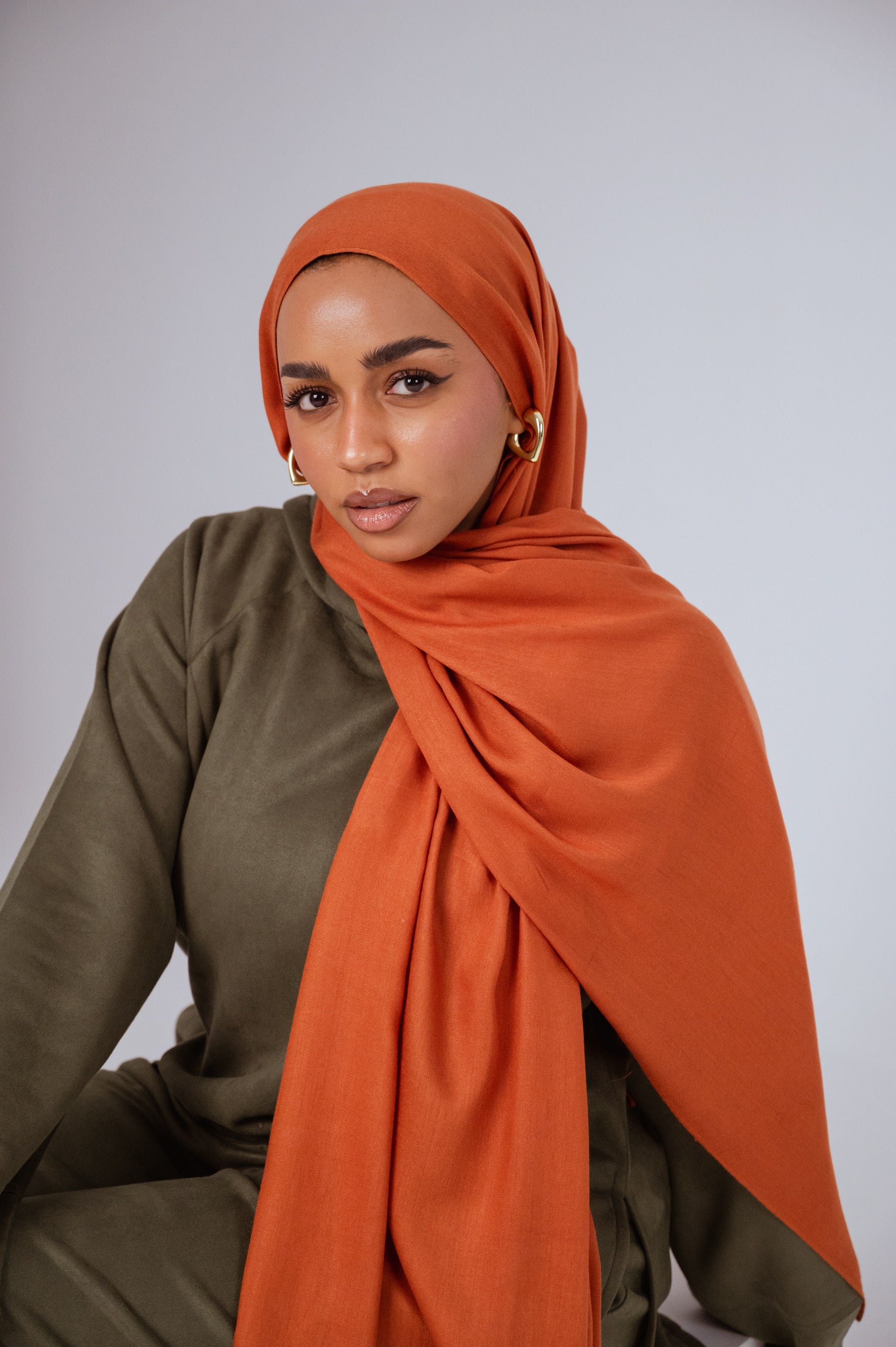 Model wearing Afire Modal Cotton Hijab styled in front drape – elegant rust hue for everyday wear.