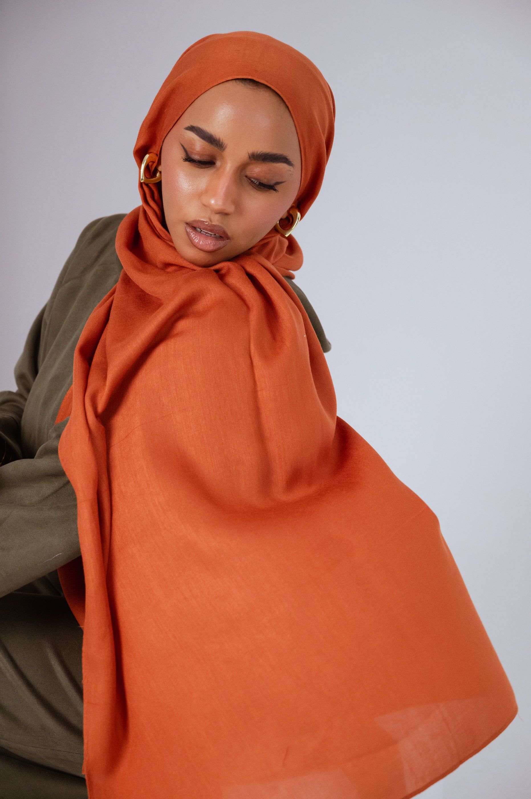 Model wearing Afire Modal Cotton Hijab styled in front drape – elegant rust hue for everyday wear.