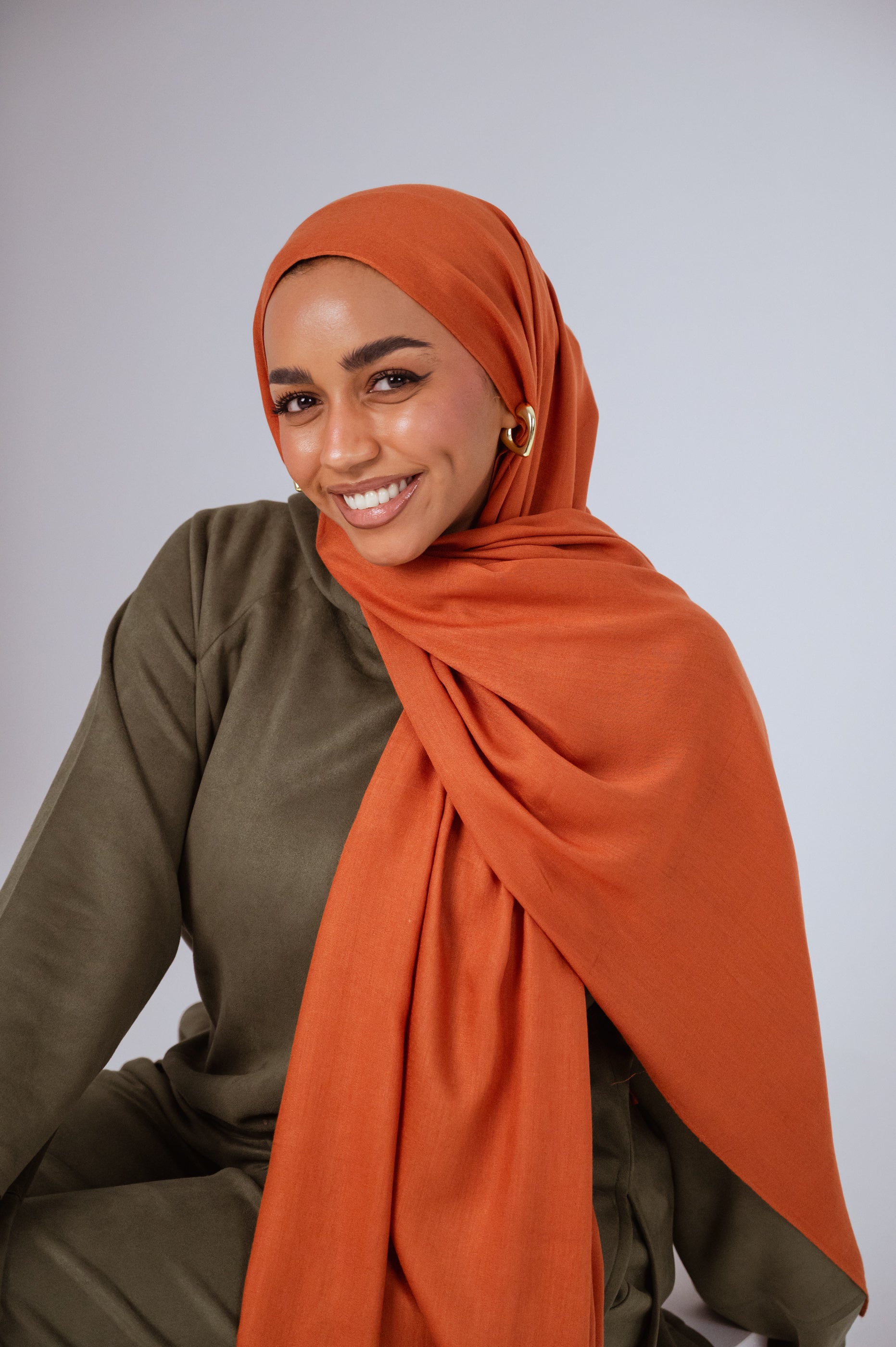 Model wearing Afire Modal Cotton Hijab styled in front drape – elegant rust hue for everyday wear.