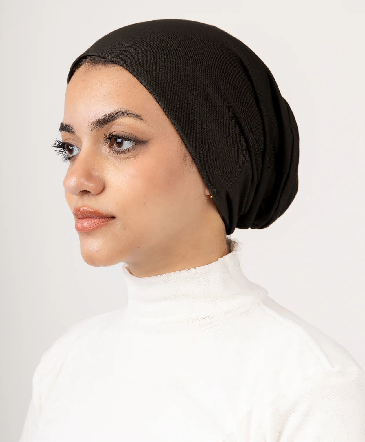 Model wearing Jaida Dark Brown No Thread Underscarf (undercap), side profile, clean no-thread look for a polished hijab base.