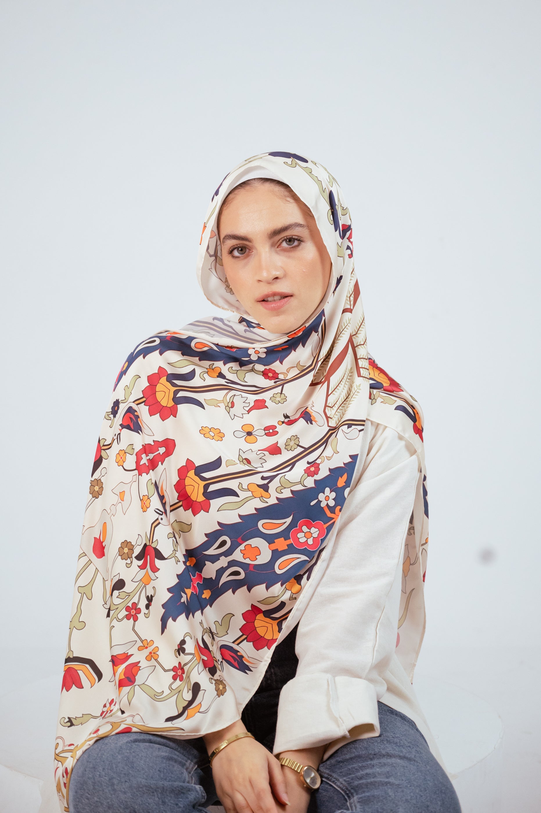 Model wearing the Andalus Satin Hijab in an ivory and gold Andalusian pattern, front view