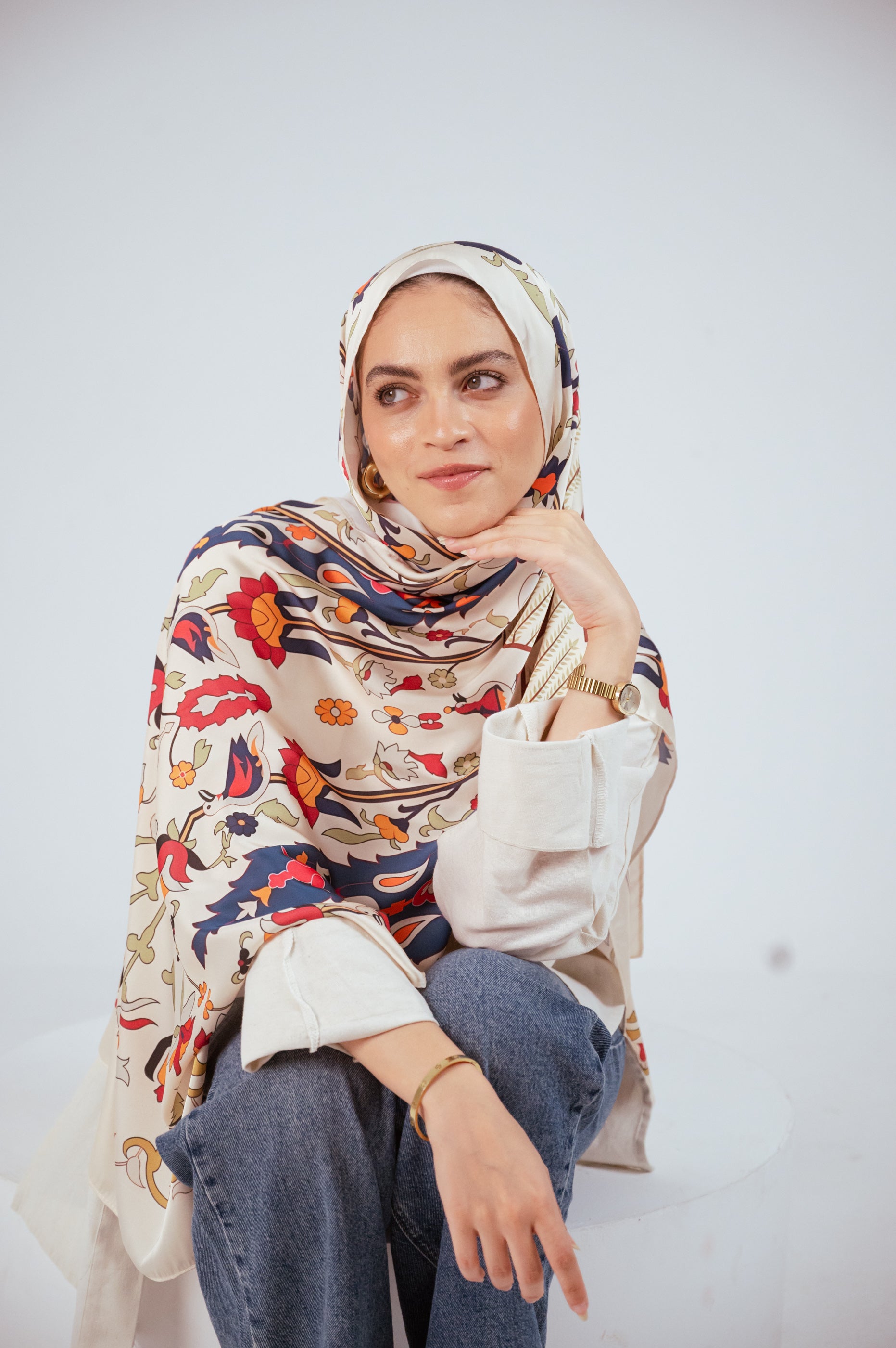 Model wearing the Andalus Satin Hijab in an ivory and gold Andalusian pattern, front view