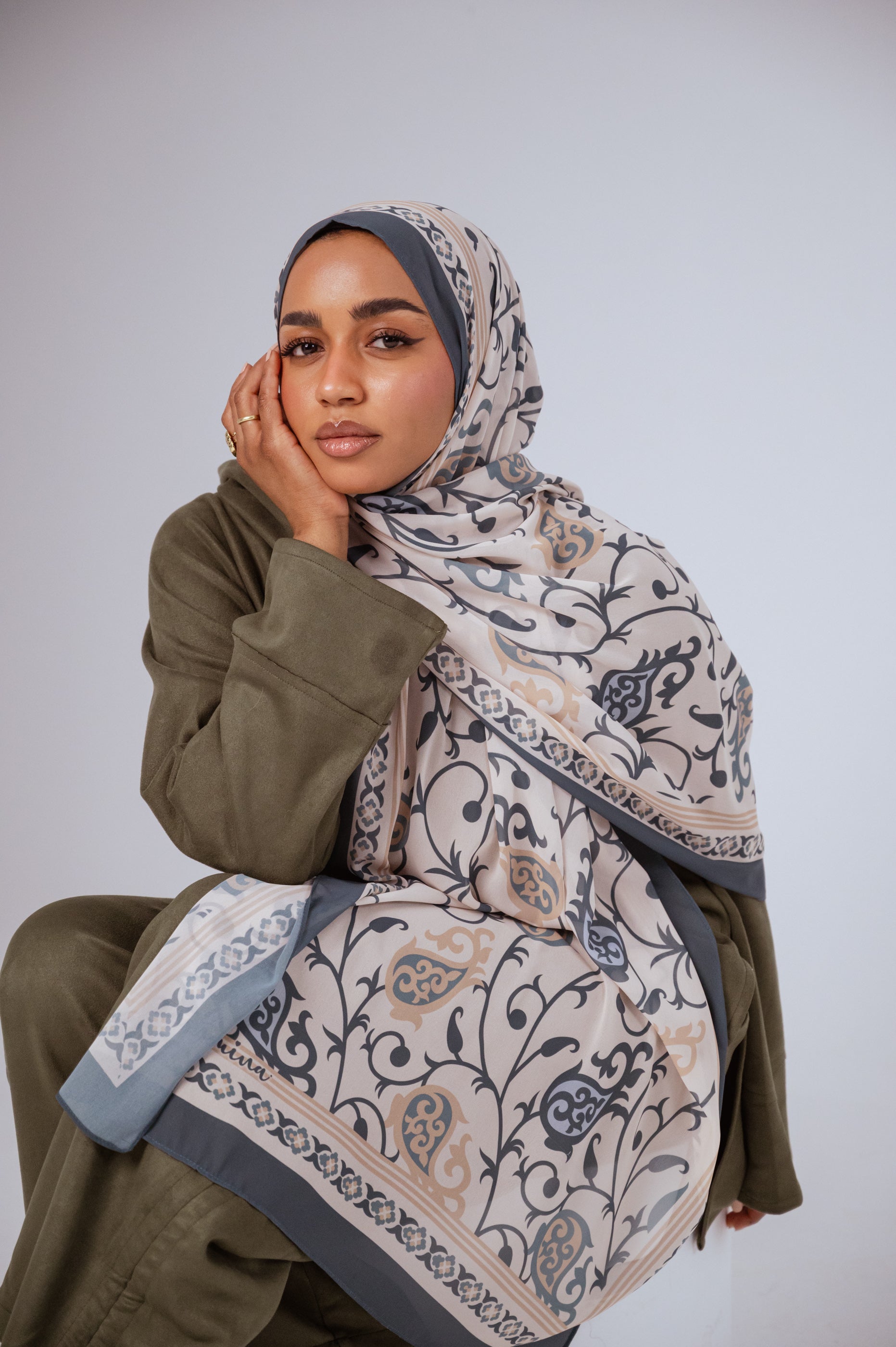 Model wearing Cordoba Serenity hijab in ivory, slate blue, and beige with Andalusian vine patterns.