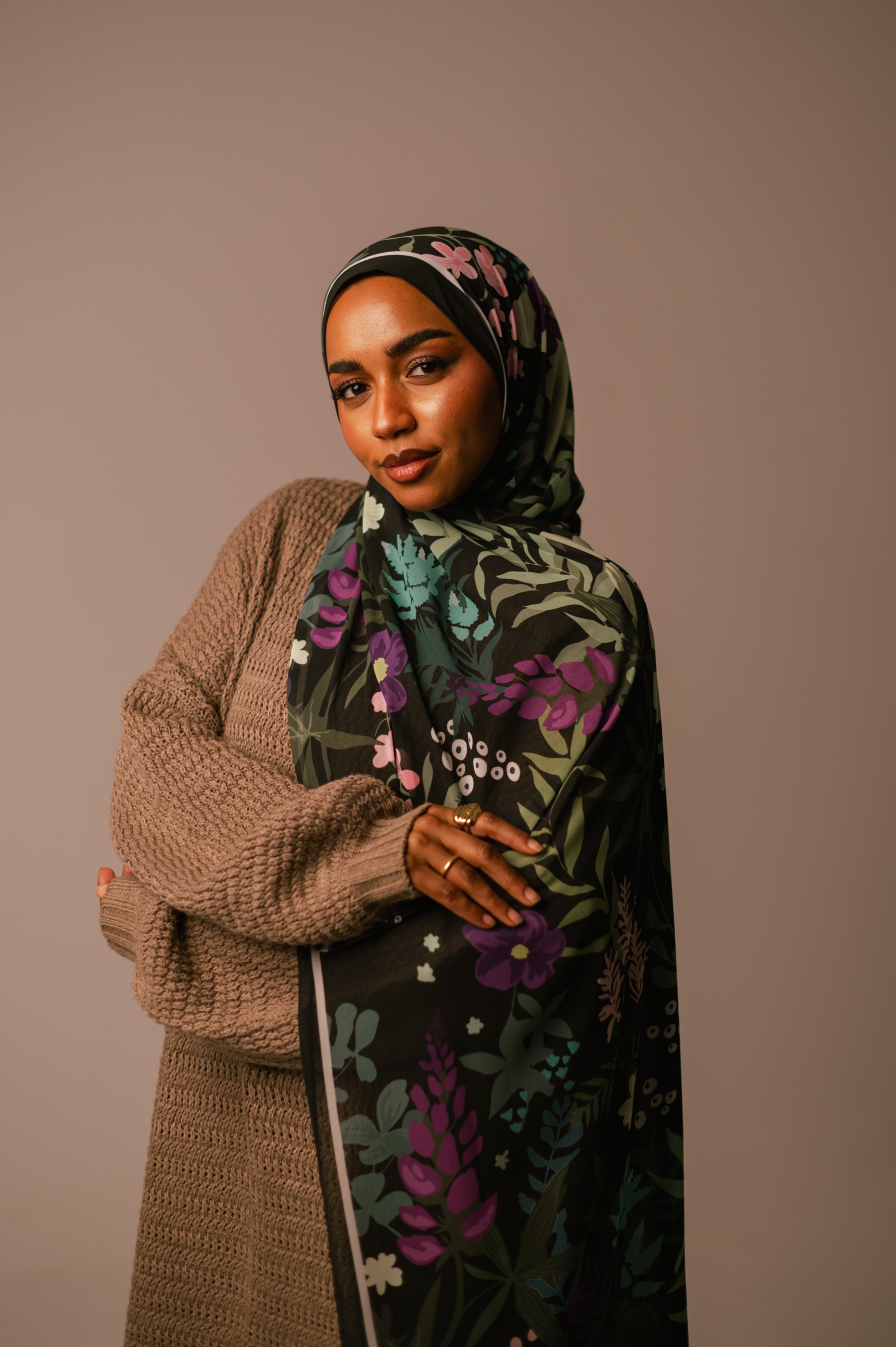 Front view of the model wearing the Garden of Whispers chiffon hijab with arms crossed, highlighting the bold floral print.