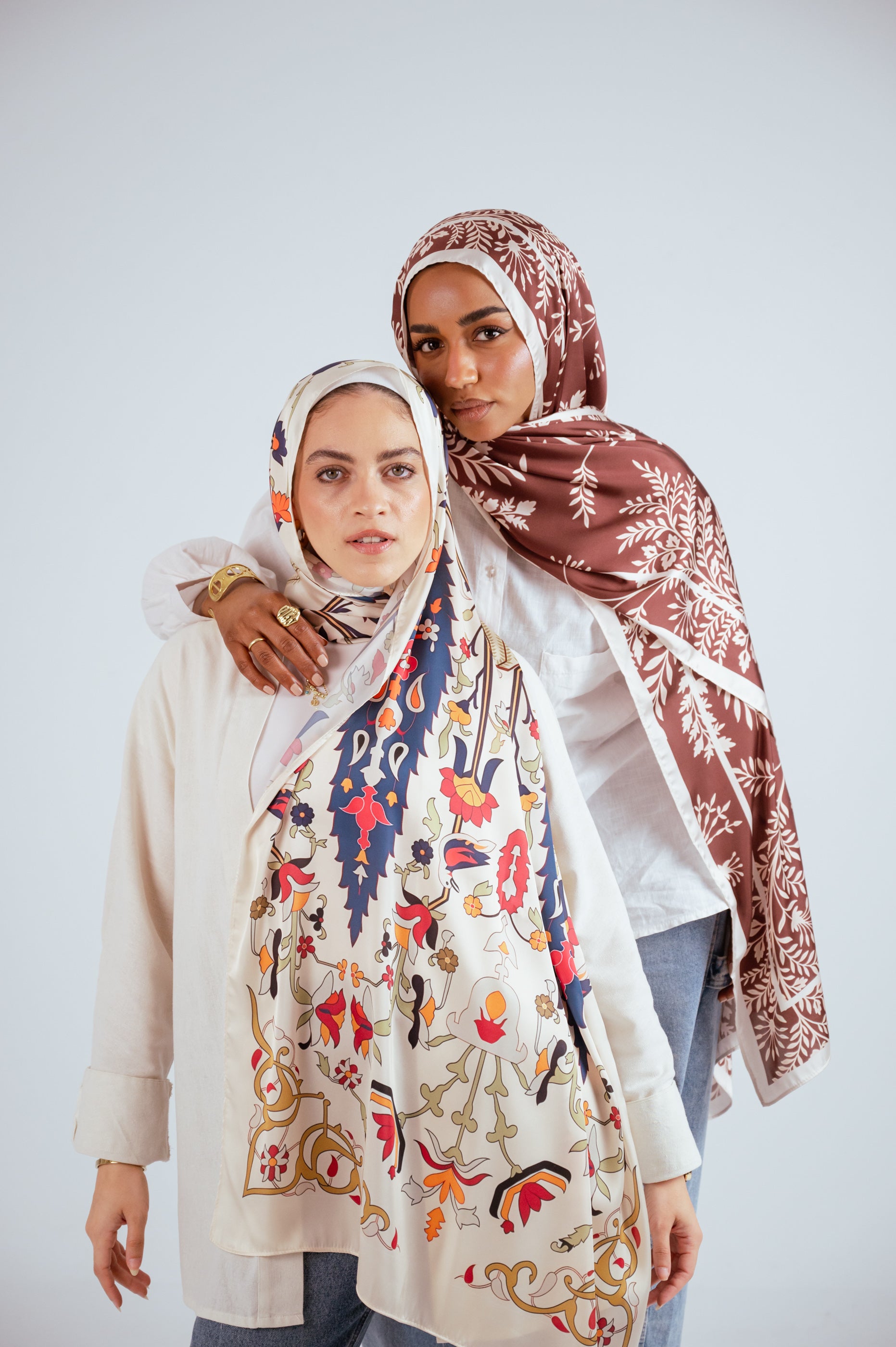 Models posing together wearing premium satin hijabs in Andalus Drape and Rose of Petra designs by Jaida.