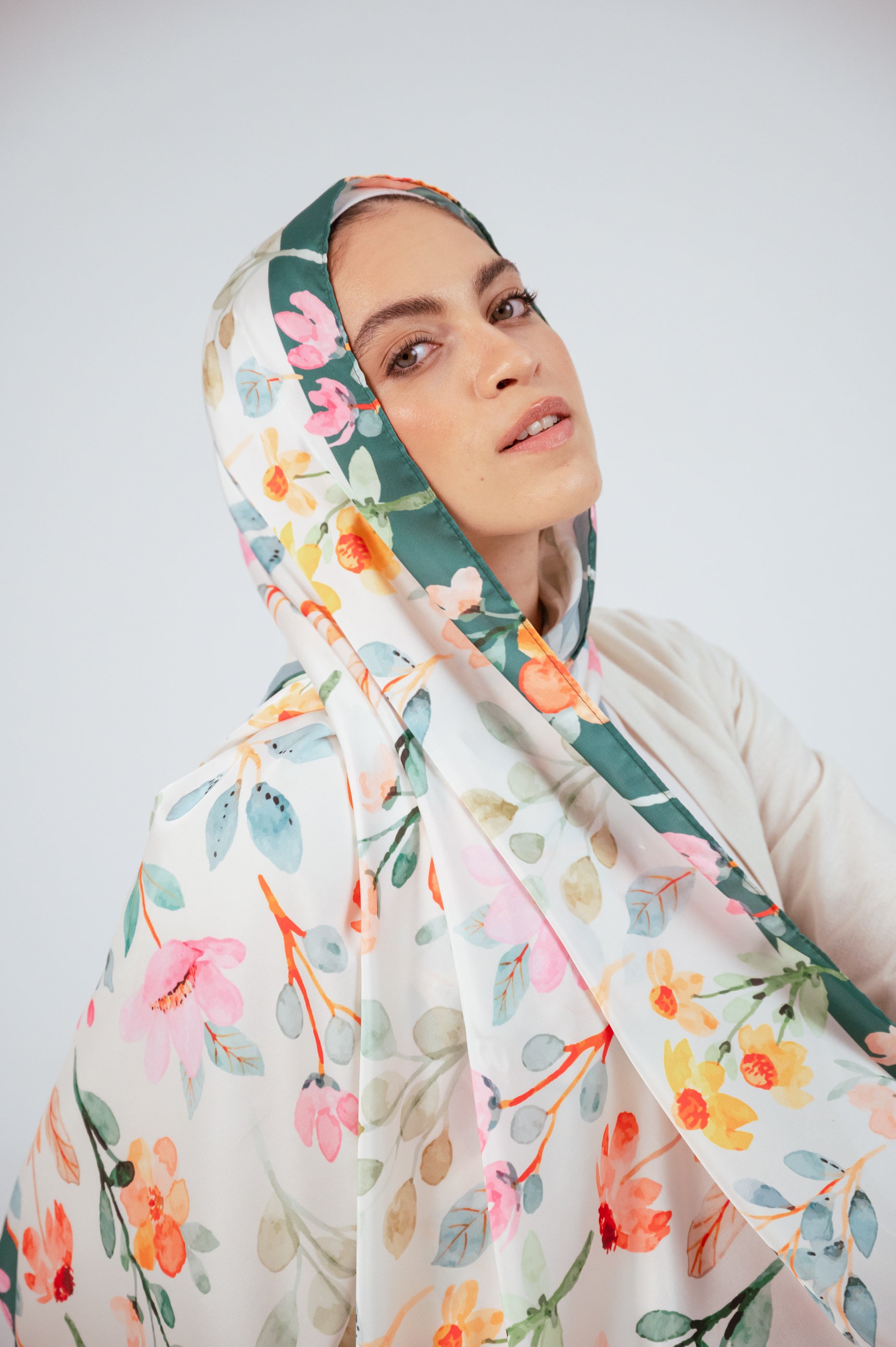 Model in Blooms of Hope – Luxury Satin Hijab looking upward, emphasizing movement and glow of the satin.