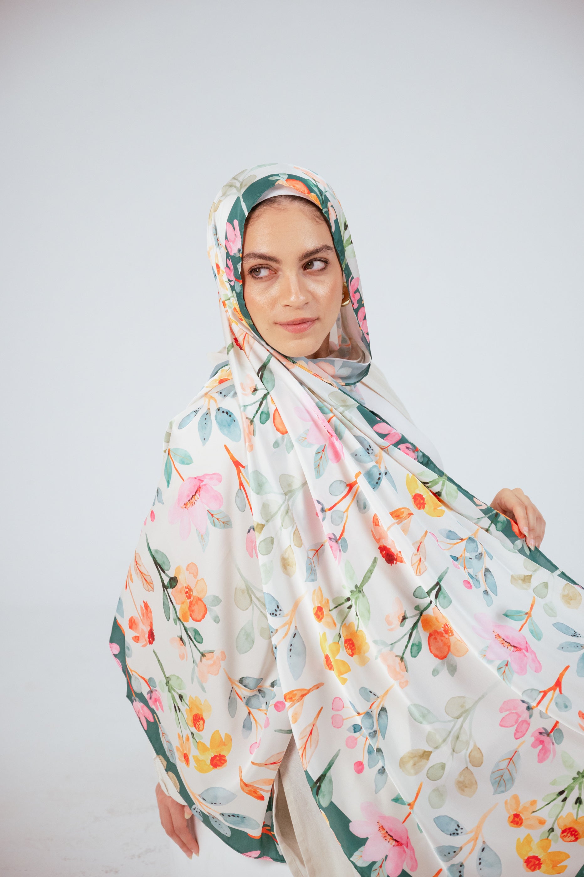 Artistic shot of Blooms of Hope – Luxury Satin Hijab cascading over the shoulder, showing full print and border.