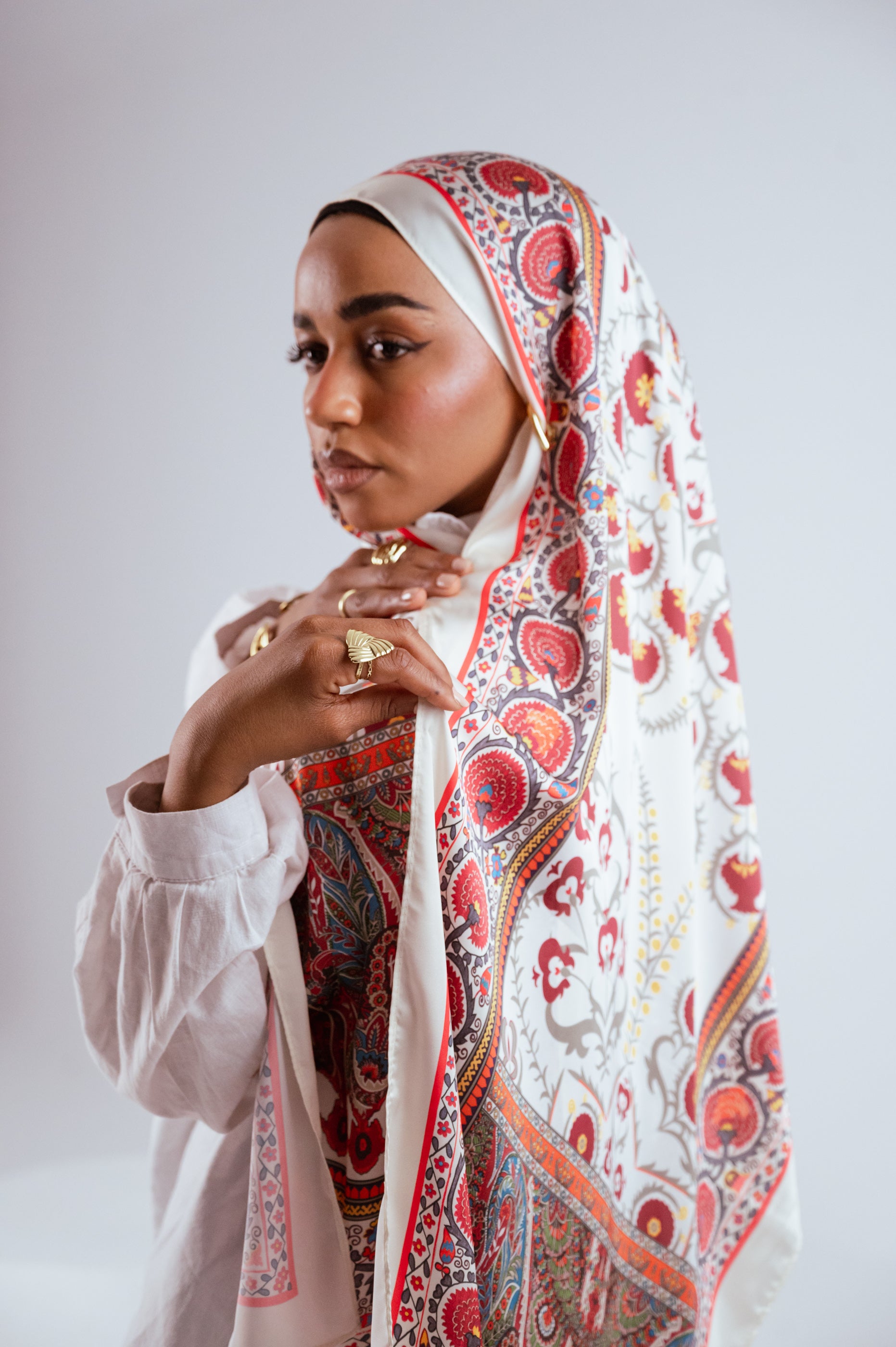 Model adjusting hijab, showing detailed paisley and floral pattern
