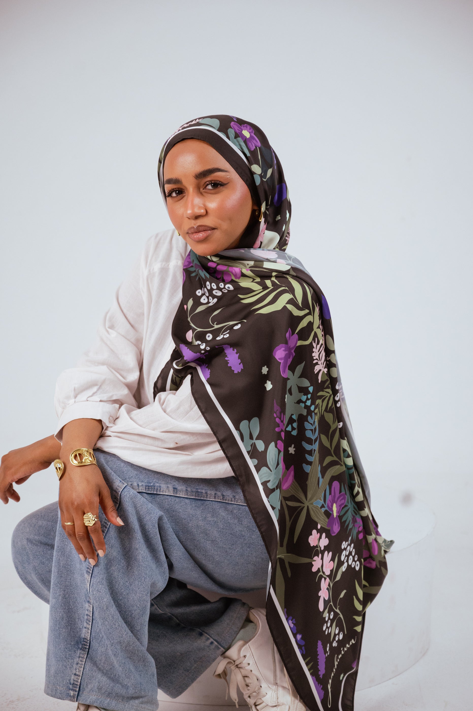 Model wearing Garden of Whispers Luxury Satin Hijab in seated pose