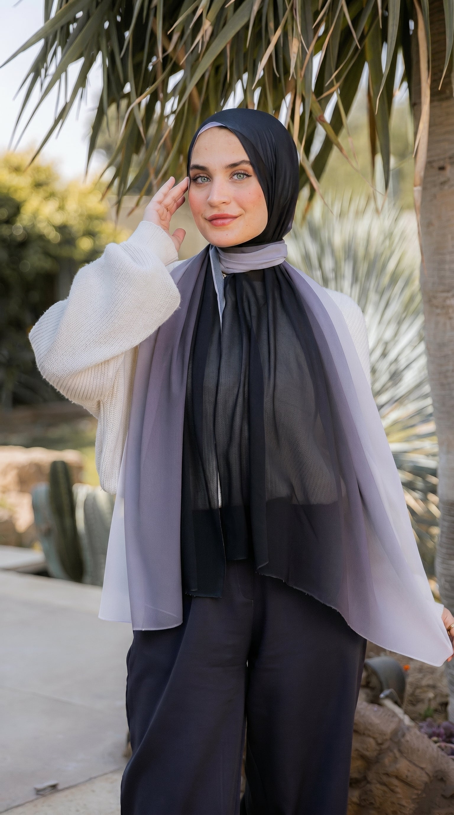 Model wearing the Lunar Mist black-to-silver ombré luxury chiffon hijab by JAIDA, styled over an ivory knit cardigan