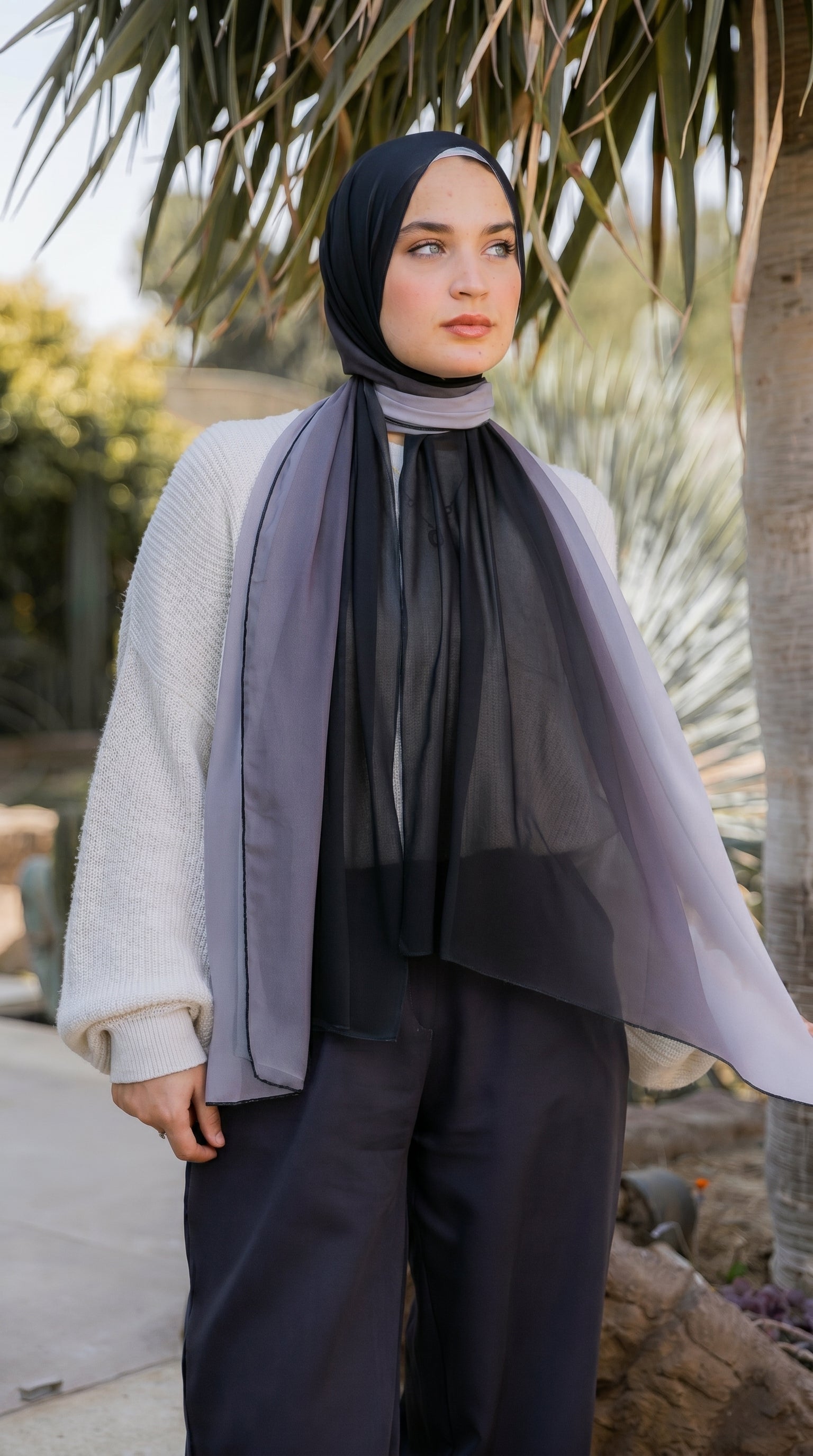 Editorial side profile of model in the Lunar Mist black and silver ombré chiffon hijab by JAIDA.
