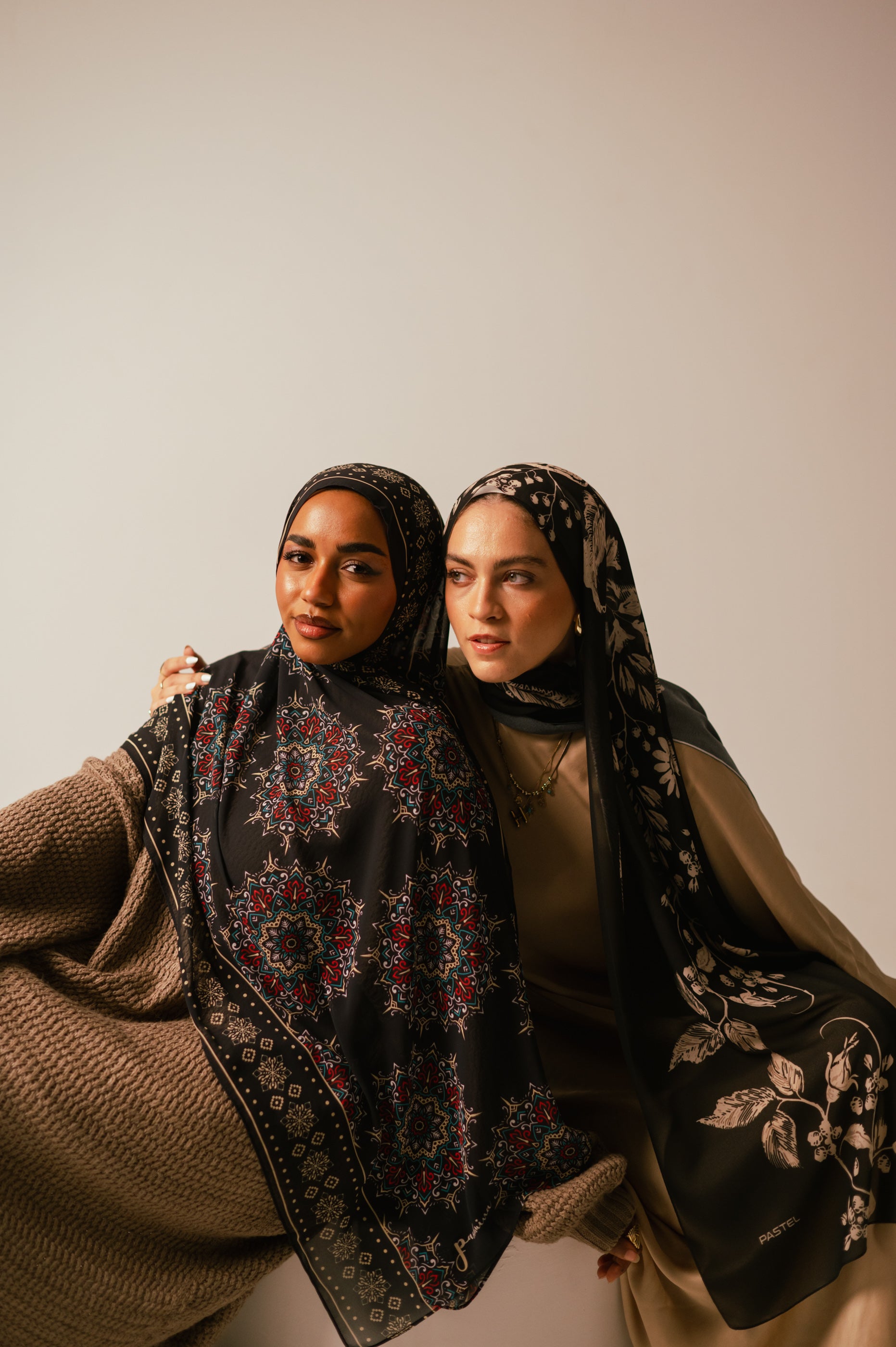 Close portrait of two models wearing Petal Shadows luxury chiffon hijab and a patterned chiffon hijab, showcasing elegant styling and soft drape.