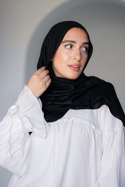 Model wearing Noir Éclipse – Modal Cotton Hijab in deep black, showcasing its soft drape and elegant matte finish.